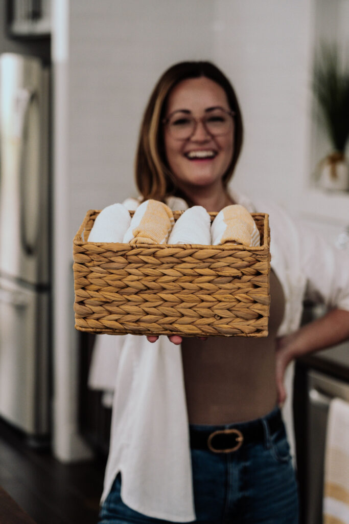 Becki Mckenna holding basket of neatly folded towels